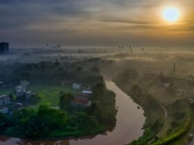 Gambar suhu bumi naik, ilustrasi planet mengeluarkan asap panas menandakan pemanasan global