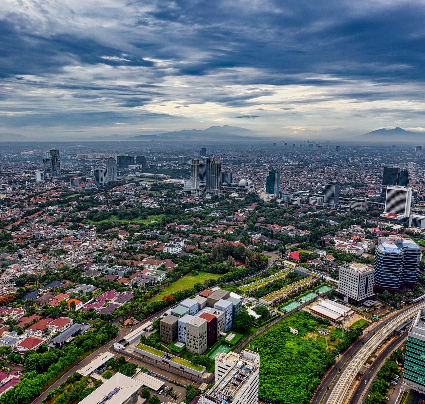 Kehidupan urban yang dinamis dengan gedung pencakar langit, lalu lintas sibuk, dan orang beraktivitas di jalan.